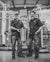 Photo of Ss Brewtech Founders standing in front of an Ss Brewtech Professional Brewhouse while hold a Ss Brewtech Brew Bucket